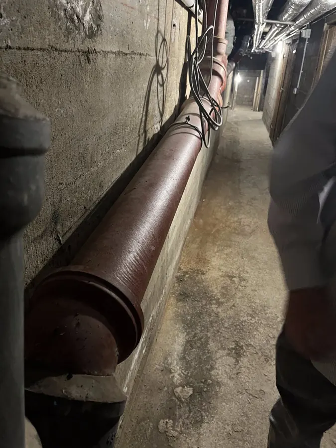 Collecteur d'évacuation en fonte dans une cave d'immeuble — débouchage Paris 1er