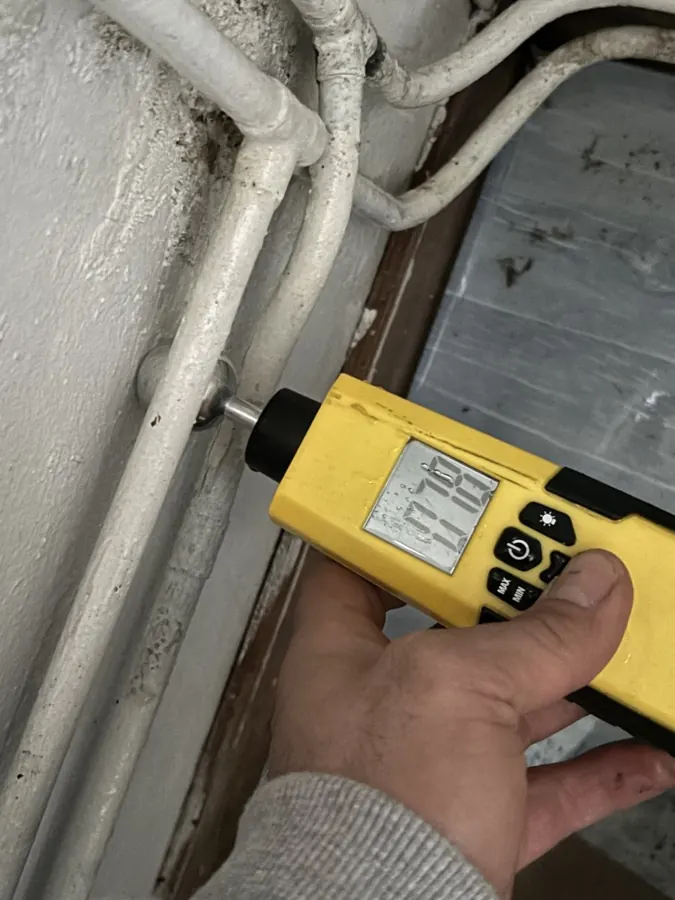 Mesure d'humidité au pied d'un mur avec un humidimètre — recherche de fuite Paris 1er